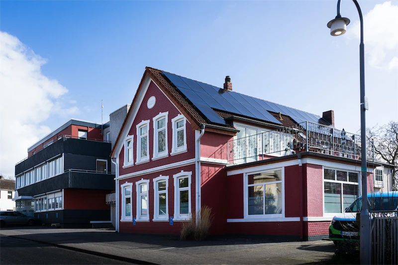 Rotes und weißes Pflegeheim mit Solaranlage auf dem Dach
